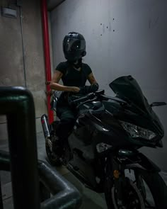 a person sitting on a motorcycle in a garage