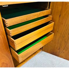 a wooden cabinet with drawers filled with green folders