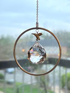 a bird is perched on top of a crystal ornament hanging from a chain