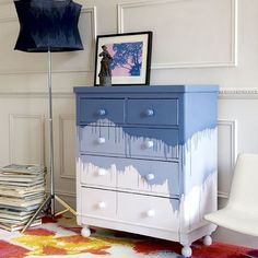 a blue and white painted dresser in a living room