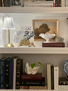 a shelf with books, vases and other items on it