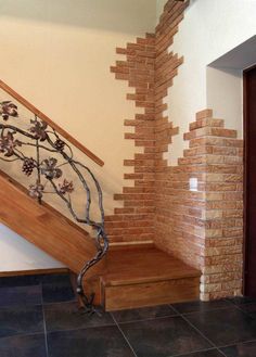 a stair case made out of bricks and wood with wrought iron handrail on top