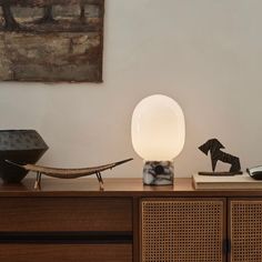 a lamp sitting on top of a wooden dresser