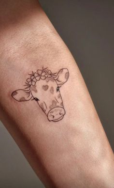 a cow with flowers on it's head is shown in this tattoo style photo