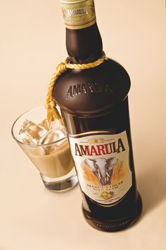 a bottle of amarfula next to a glass filled with ice