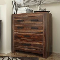 a large wooden dresser sitting on top of a hard wood floor next to a window