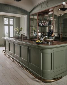 an elegant kitchen with green cabinets and wood floors