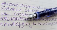 a close up of a fountain pen on top of a piece of paper with writing