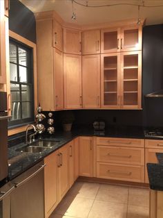 a kitchen with wooden cabinets and black counter tops