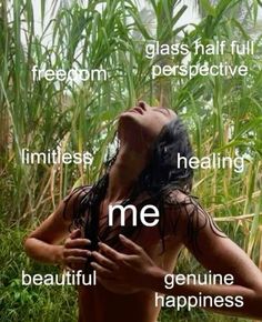 a woman with her eyes closed standing in front of some tall grass and looking up at the sky