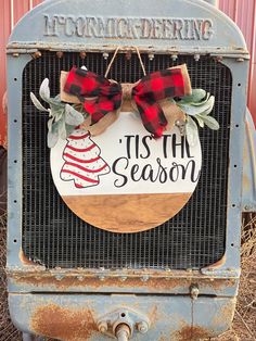 an old truck with a christmas decoration on it's front and the words tis the season