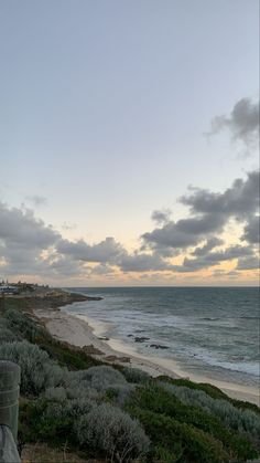 the beach is next to an ocean with waves coming in