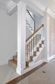 a white staircase with wooden handrails in a house