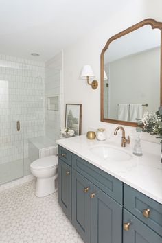 a bathroom with white tile and blue cabinets