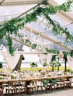 an outdoor tent with tables and chairs set up for a wedding reception under the canopy