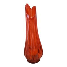 an orange glass vase is shown on a white background and it appears to be in the shape of a flower