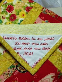 a close up of a quilted piece of cloth with words written on the side