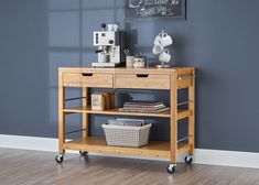 a wooden table with two drawers and a basket on the bottom shelf next to it