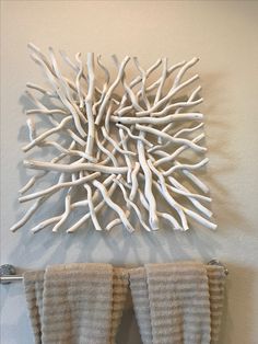 a pair of boots hanging on a wall next to a towel rack with white branches