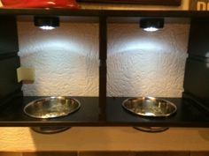 two stainless steel bowls sitting on top of a black counter next to a red fire hydrant