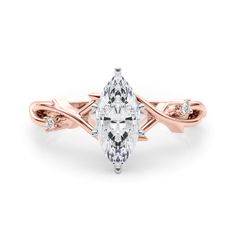 a rose gold ring with a pear shaped diamond in the center and two diamonds on each side