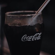 a glass filled with black liquid sitting on top of a table