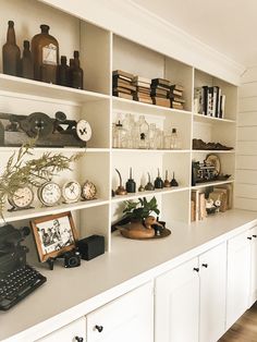 the shelves are filled with different types of clocks and other things on display in front of them