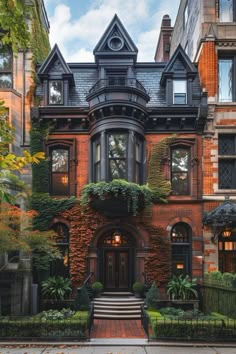 an old brick house with many windows and plants on the front