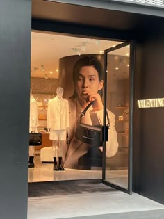 a mannequin's dummy in the window of a clothing store with an advertisement on it