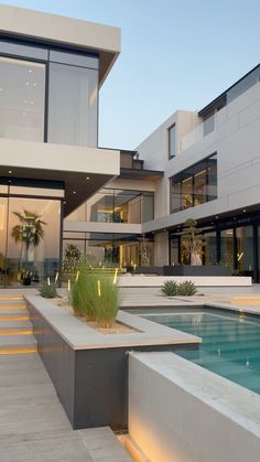 a modern house with a pool in the foreground and stairs leading up to it