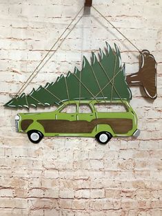 a green car with a christmas tree on it hanging from a brick wall