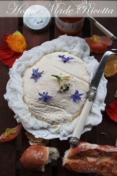 a cake with blue flowers on it sitting on a table next to bread and butter