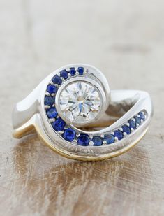 Asymmetrical Band Ring with Sapphire & Diamonds. caption:Shown with a 0.75ct center diamond Engagement Ring Bezel, Round Cut Diamond Engagement Ring, Sapphire Rings, Bezel Set Ring, Wave Ring, Sapphire Engagement Ring Blue, Hand Ring, Yellow Gold Setting, Sapphire Diamond Ring