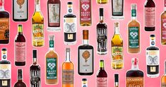 many different types of alcohol on a pink background