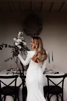 a woman standing in front of a table with flowers