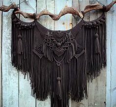 the cow horns are adorned with tassels and other decorative things hanging on a wooden wall