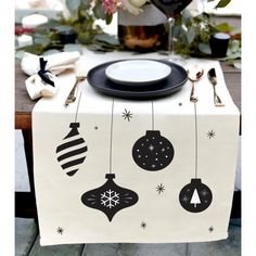 a white table topped with a black plate and christmas decorations