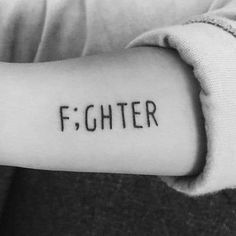 a person's arm with the word fighter written on it, in cursive font