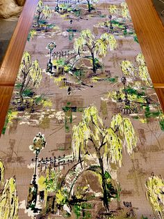 a table runner with trees on it in front of a dog laying on the floor