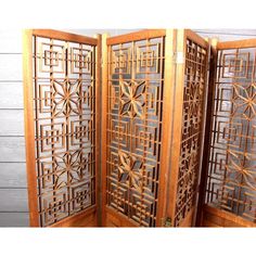 an intricately carved wooden room divider with four panels on each side and one panel in the middle