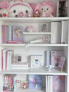 a white book shelf filled with lots of books and stuffed animals on top of it