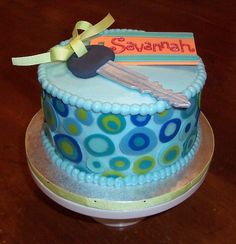 a birthday cake decorated with blue and green polka dot design on a wooden table top