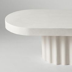 a white round table sitting on top of a gray floor