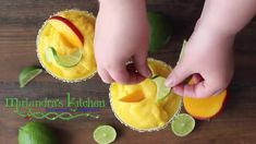 someone is peeling an apple into a small bowl filled with guacamole and limes