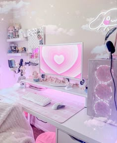 a desk with a computer monitor, keyboard and mouse on it in front of a pink wall