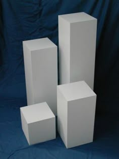 three white boxes are stacked on top of each other in front of a blue background