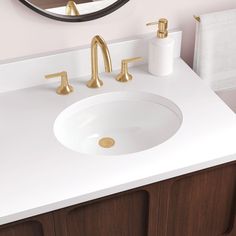 a bathroom sink with two faucets and a mirror above it