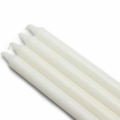 four white candles sitting on top of each other