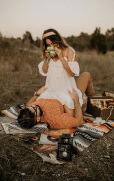 a man and woman sitting on the ground eating food