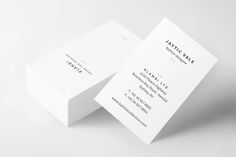 two white business cards sitting on top of each other